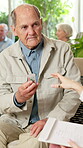 Medical, old man or nurse in center with pills, diagnosis or medication plan in elderly care. Health, senior person or caregiver with help, recovery prescription or treatment advice in nursing home.