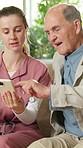 Nursing home, old man and nurse with phone, talk and explaining medical schedule on app and website. Healthcare, caregiver and senior person with mobile, online and help with telehealth appointment