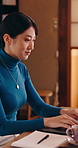 Laptop, typing and Asian woman in home with remote work, coffee or smile for blog article submission. Japanese person, freelance writer and happy in house with tea, computer or finished online story.