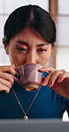 Laptop, coffee and Asian woman in home with remote work, thinking and smile for blog article idea. Happy, Japanese person or freelance writer in house with tea, computer or proofreading online story.