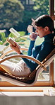 Relax, reading book and Asian woman with tea in home, fiction story or tale on weekend break. Japanese person, drink and novel in house for fantasy, chill and literature hobby with chapter on chair