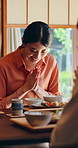 Smile, Asian woman and prayer at house with food, traditional greeting and gratitude for lunch meal. Family, daughter and bow in lounge with appreciation, buffet feast and authentic Chinese cuisine