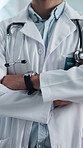 Doctor, hands and arms crossed in hospital with medical service, cardiology specialist and expertise. Confident, man and cardiologist in clinic with healthcare experience, work uniform and about us.