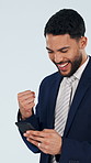 Fist pump, space and businessman with phone in studio for winning, achievement or finance bonus. Happy, cellphone and financial manager on app for celebration of investment payout on white background