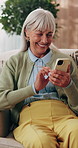 Phone, relax and senior woman on sofa in home for texting, research or chatting on mobile app. Happy, technology and elderly person in retirement with reading blog, website or social media in house.