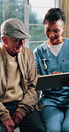 Consultation, nurse or old man in home with tablet, treatment plan or medical record in senior care. Happy, caregiver or elderly person with tech, diagnosis report or health assessment in retirement.