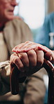Nurse, elderly and holding hands with cane for assisted living, healthcare or support in house. People, caregiver or health worker with patient for senior care, understanding or trust in old age home