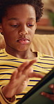 Online, sofa and child with tablet for game, scroll entertainment or educational app. African boy, home and relax with tech for digital puzzle, internet search and browsing website for development