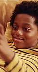 Phone, game and child relax on couch, interactive website and online entertainment on weekend. African boy, apartment and mobile gaming at home in living room, smile and play with app on internet