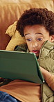 Scroll, home and child with tablet for game, online entertainment or educational app. African boy, sofa and relax with tech for digital puzzle, internet search and browsing website for development