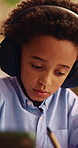 Child, tablet and writing with headphones for education, virtual classroom or online lesson in home. African boy, student and digital tech for distance learning, elearning app or homeschooling