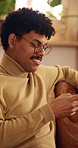 Phone, scroll and man on sofa in home with texting, chatting or communication on social media app. Happy, technology and person with cellphone for email, FAQ or inquiry on website in apartment.