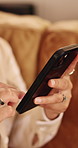 Woman, hands and scroll in house with phone, social media app and browsing for online entertainment. Female person, internet connectivity and text message in home with tech, mobile chat and website.