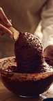 Mix, hands and woman with cake batter in kitchen for baking, dessert or cupcakes in home. Small business, wooden spoon and baker with chocolate mixture in bowl for sweet treat order in house.