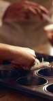 Hands, baking and child with parent in home, development and culinary skills for dessert preparation. Learning, recipe and family with cupcake dough, cooking together and person with kid in house