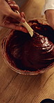 Mix, hands and baker with cake batter in kitchen for baking, dessert or cupcakes for small business. Confectionery career, wooden spoon and woman with chocolate mixture for sweet treat order in house
