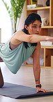 Serious, woman and stretching on yoga mat in home, wellness and physical activity to improve posture. Fitness, balance and self care with warm up routine, person and bird dog pose for health in house