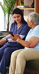 Caregiver, help and old woman in nursing home with phone, discussion or website navigation advice. Nurse, senior person and talk on sofa with how to setup tech, app or assistance for digital literacy