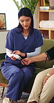 Caregiver, checkup and old woman in home with blood pressure machine, healthcare and retirement help. Senior person, medical worker and talk with equipment for hypertension test, advice and wellness.