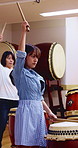 Taiko, women and playing drums in studio for performance practice, learning or cultural song. Talent, asian female band or drummer group with bachi for percussion, festival rehearsal or timing rhythm