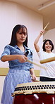 Women, drums and playing with sticks in class for music production, sound or taiko tradition. Female people, instrument or learning percussion with lesson for culture, musical audition or performance