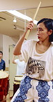 Taiko, lesson and woman with drums for practice, rehearsal or learning cultural choreography. Bachi percussion, creative and person in Japanese band for sound coordination, performance or rhythm.