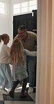 Door, home and children running to dad for hug, welcome and greeting for arrival or return from work. Happy man, girl kids or daughters in family house with love, care or reunion with safety
