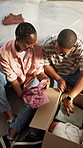 Couple, discussion and unboxing in new home with clothes, help and bonding together for relocation. Above, married black people and moving in apartment with unpacking, apparel and happy relationship.