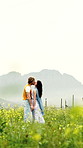 Holiday, kiss and couple in field with love, bonding and happy moment on outdoor trip. Space, smile and people with forehead touch, romantic relationship or playful connection on countryside getaway.