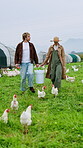 Agriculture, poultry and couple with bucket in field for feeding, flock management or trade. Walk, talk and people in agribusiness for egg collection, livestock monitoring or farmer industry on farm