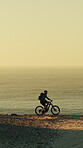 Mountain bike, man or cycling on cliff edge at sunset for coastal adventure, off road travel or ride. Mockup space, cyclist and bicycle journey outdoor for seaside trail, scenic route and nature tour