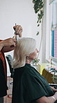 Woman, hairdresser and haircut in salon for treatment, hair maintenance and grooming service. Mature client, stylist and scissors in beauty parlor for trimming, pamper day and haircare for makeover