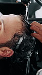 Man, relax or washing hair in salon with shampoo, sink water and foam for hygiene at appointment. People, hairstylist and clean client scalp in small business with liquid soap, grooming or treatment.
