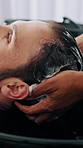 Man, scrub and washing hair in salon with shampoo foam, maintenance and hygiene for grooming service. People, hairdresser and clean client scalp in sink with liquid soap, hydration and treatment.