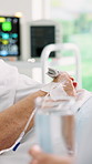 Hands, healthcare and water with patient in hospital bed for hydration, recovery or treatment. Drink, oxygen monitor and medical care with senior person in clinic for assistance, help or wellness