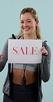 Sale, personal trainer and face of woman in studio for gym membership discount, offer and poster. Coaching advertising, pointing and promotion with person and sign on blue background for announcement