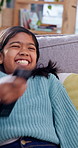 Happy, child and jump on sofa with remote for watching tv, funny movie selection and holiday break. Laughing, girl kid and change channel in home for cartoon program, comedy show and relax on weekend