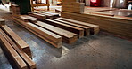 Carpentry, lumber and material in empty factory for craftsmanship, manufacturing or production. Creativity, industry and timber with wood in warehouse interior for furniture business or storage