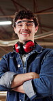 Carpenter, arms crossed and face of man in warehouse for woodworking, factory manager and pride. Timber craftsman, smile and furniture production with person in workshop for manufacturing and laugh