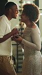 Love, coffee and whisper with black couple in home for support, romantic connection and partner. Happy, commitment and laughing with man and woman talking in house for drink, calm and care together