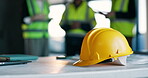 Civil engineering, laptop and helmet on table in meeting, teamwork and ideas for renovation project. Architect, equipment and people with tech, discussion and collaboration for property development