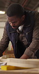 Carpenter, man and design in factory with timber, creativity and problem solving for manufacturing. Black person, thinking and woodwork designer in workshop with planning, restoration and production.