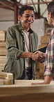 Carpenter, team and handshake in workshop with tablet, conversation and planning furniture design. Designer, people and shaking hands in factory with tech, research or artisan for woodwork production