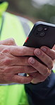 Hands, phone and construction worker on site for feedback on maintenance, building or repairs. Man, technology and civil contractor with email update on renovation, project or property development.