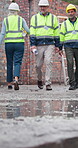 Architect, team and walking with blueprint on construction site, inspection or property development. Civil engineer, legs and people with document, discussion and collaboration for renovation project