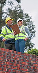 Clipboard, collaboration and construction workers site with planning building, repairs or renovation. Checklist, rooftop and civil engineers in discussion for property development or maintenance.