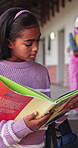 Reading, book and education with child in school hallway for learning, knowledge and academy. Study, literacy development and growth with student in corridor of campus for scholarship and project