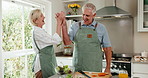 High five, cooking and senior couple in home kitchen with laugh, bonding and love in marriage. Happy, food and ingredients for health and people with hug, talking and help in house for retirement