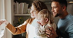 Family, happy and view at window in house, parents and baby with development, bonding and care. Mother, father and child with pointing for curiosity, connection and relationship with love in home