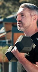 Weights, sports and man outdoor for workout, muscle growth or body building in morning at house. Fitness, equipment and mature person with dumbbells for arm exercise, wellness or active in backyard.